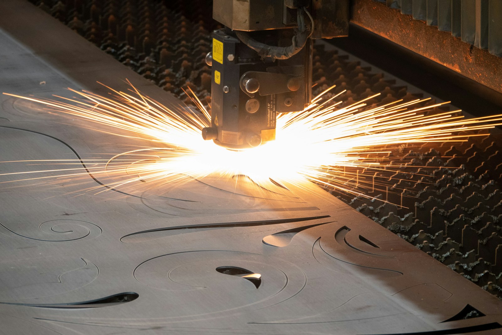 IR laser cutting through a metal surface at higher throughput